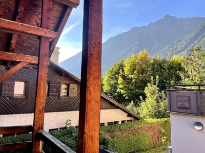 a view of a house with mountains in the background at Cosy appartement centre chamonix in Chamonix-Mont-Blanc
