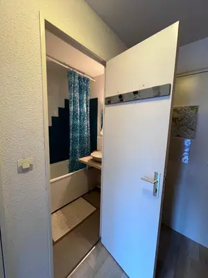 a door leading into a bathroom with a sink at Aux Pieds des pistes en plein soleil in Les Contamines-Montjoie