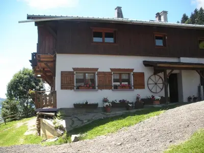 a house on a hill with flowers in front of it at Chalet L' Irrawaddy in Megève