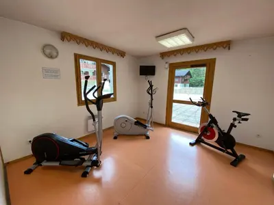 a gym with three exercise bikes in a room at Apt Sakura - Le Grand Tetras in Samoëns