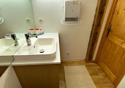 a bathroom with a white sink and a mirror at Apt Sakura - Le Grand Tetras in Samoëns