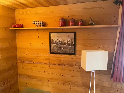 a room with a wooden wall with a picture and a lamp at LOUE STUDIO MEGEVE in Megève
