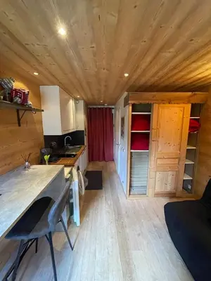 a small kitchen in a tiny house with a wooden ceiling at LOUE STUDIO MEGEVE in Megève