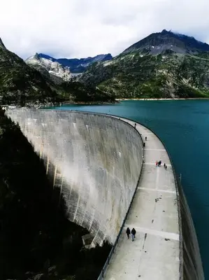 a large dam with people standing on it next to the water at French Alps Luxury in Vallorcine