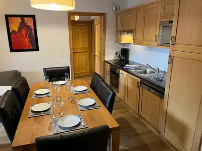 a kitchen with a long wooden table with black chairs at French Alps Luxury in Vallorcine