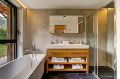 a bathroom with a sink and a tub and a mirror at Black Pearl in Chamonix-Mont-Blanc