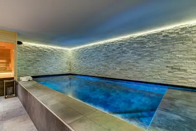 a swimming pool in a room with a brick wall at Black Pearl in Chamonix-Mont-Blanc