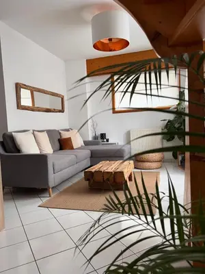 a living room with a couch and a table at Duplex Sallanches - Terrasse, Centre & Parking by AlpenlySallanches in Sallanches