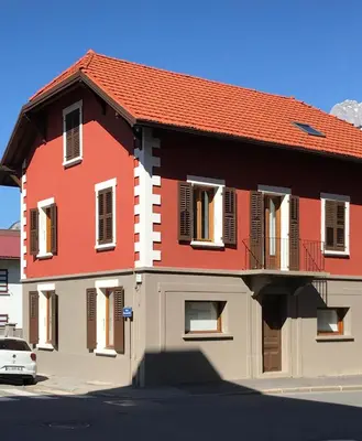 a red and white house with a car parked in front at Duplex Sallanches - Terrasse, Centre & Parking by AlpenlySallanches in Sallanches