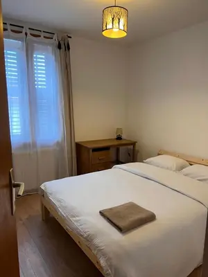 a bedroom with a white bed and a window at Duplex Sallanches - Terrasse, Centre & Parking by AlpenlySallanches in Sallanches