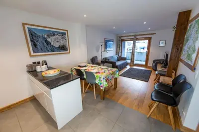 a kitchen and living room with a table and chairs at Grand Paradis B01 - Modern with great location in Chamonix-Mont-Blanc