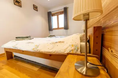 a small bedroom with a bed and a lamp at Grand Paradis B01 - Modern with great location in Chamonix-Mont-Blanc