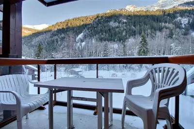 a table and chairs on a balcony with a view at Appartement vue montagne proximité ski et parcours TMB in Les Contamines-Montjoie