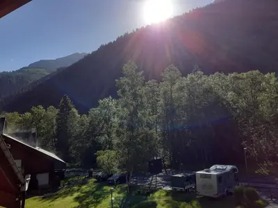 an rv and a truck parked in front of a mountain at Appartement vue montagne proximité ski et parcours TMB in Les Contamines-Montjoie