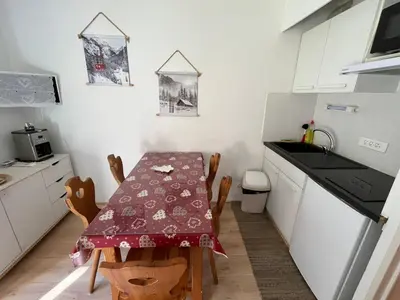 a kitchen with a table and chairs and a kitchen with white cabinets at Appartement vue montagne proximité ski et parcours TMB in Les Contamines-Montjoie