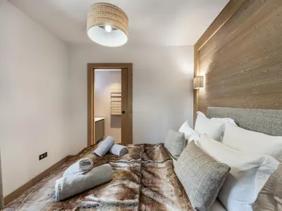 a bedroom with a large bed with a wooden headboard at Bel appartement à Megève dans résidence avec piscine - FR-1-569-105 in Megève