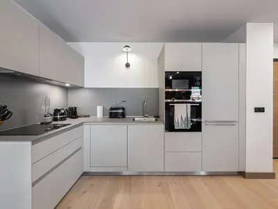 a white kitchen with white cabinets and appliances at Bel appartement à Megève dans résidence avec piscine - FR-1-569-105 in Megève