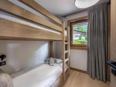 a bedroom with two bunk beds and a window at Bel appartement à Megève dans résidence avec piscine - FR-1-569-105 in Megève
