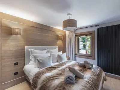 a bedroom with a large bed with towels on it at Bel appartement à Megève dans résidence avec piscine - FR-1-569-105 in Megève