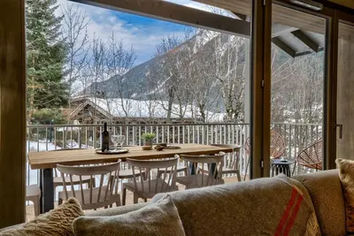 a room with a table and chairs and a large window at White Pearl Apartments in Chamonix-Mont-Blanc