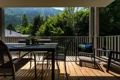 a patio with a table and chairs on a deck at White Pearl Apartments in Chamonix-Mont-Blanc