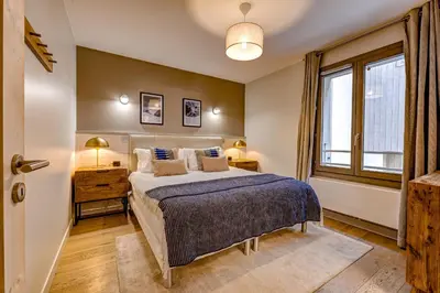 a bedroom with a bed and a window at White Pearl Apartments in Chamonix-Mont-Blanc