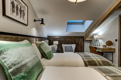 a bedroom with two beds and a desk at White Pearl Apartments in Chamonix-Mont-Blanc