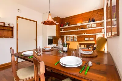 a dining room with a wooden table with plates on it at Appartement Belle Epoque - Happy Rentals in Chamonix-Mont-Blanc