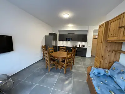 a kitchen and dining room with a table and chairs at Appartement au pied du Mont-Blanc 2! in Sallanches