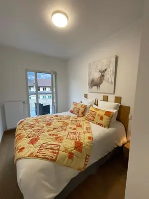 a bedroom with a bed with a quilt on it at Appartement au pied du Mont-Blanc 2! in Sallanches