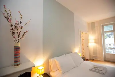 a bedroom with a white bed and a vase with flowers at Majestic T2 calme, spacieux, central, avec parking in Chamonix-Mont-Blanc