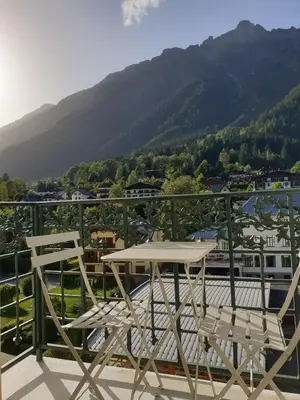 a table and two chairs on a balcony with a mountain at Majestic T2 calme, spacieux, central, avec parking in Chamonix-Mont-Blanc