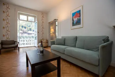 a living room with a green couch and a table at Majestic T2 calme, spacieux, central, avec parking in Chamonix-Mont-Blanc