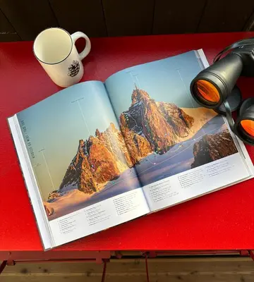 an open book on a red table with a cup of coffee at Mont-Blanc View - Panoramic Balcony - Chamonix Centre in Chamonix-Mont-Blanc