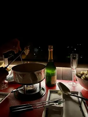 a table with a pot and a bottle of wine at Mont-Blanc View - Panoramic Balcony - Chamonix Centre in Chamonix-Mont-Blanc