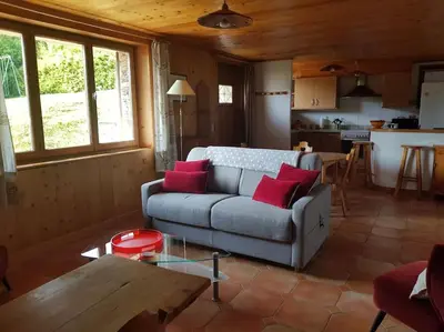 a living room with a couch and a table at Appartement belle vue in Combloux