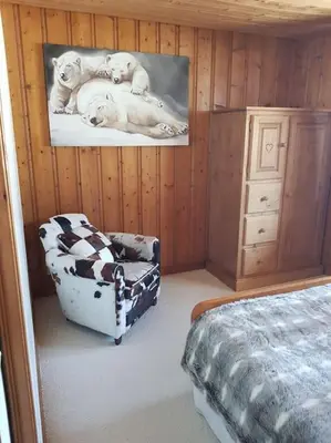 a bedroom with a bed and a chair with two dogs at Appartement belle vue in Combloux