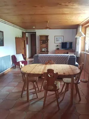 a wooden table and chairs in a living room at Appartement belle vue in Combloux