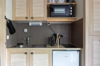 a tiny house with a dining table and a bed at Adorable studio, proche pistes de ski, à Combloux in Combloux