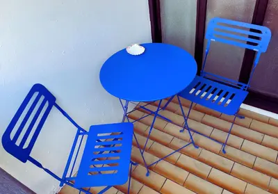 a wooden deck with a table and an umbrella at Adorable studio, proche pistes de ski, à Combloux in Combloux
