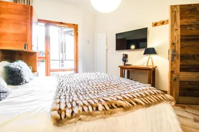 a bedroom with a large bed and a television at Joli, spacieux appartement T3 sud ski aux pieds, parking in Flaine
