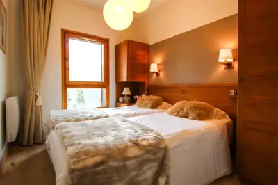 two beds in a bedroom with a window at Joli, spacieux appartement T3 sud ski aux pieds, parking in Flaine