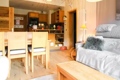 a living room with a table and a dining room at Joli, spacieux appartement T3 sud ski aux pieds, parking in Flaine