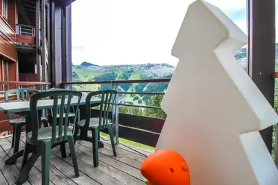 a balcony with tables and chairs and a view at Joli, spacieux appartement T3 sud ski aux pieds, parking in Flaine
