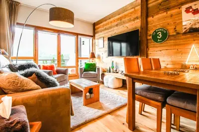 a living room with a couch and a table at Joli, spacieux appartement T3 sud ski aux pieds, parking in Flaine