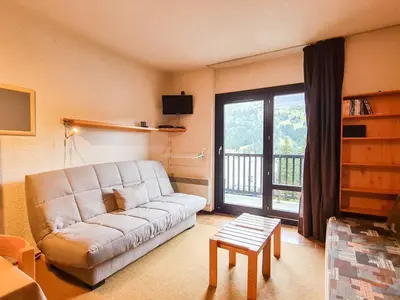 a living room with a couch and a large window at Studio confortable, balcon sud, proche pistes, casier à ski - FR-1-425-203 in Arâches-la-Frasse
