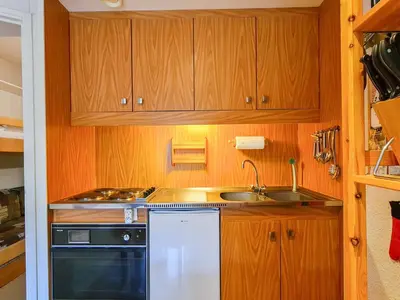 a small kitchen with wooden cabinets and a sink at Studio confortable, balcon sud, proche pistes, casier à ski - FR-1-425-203 in Arâches-la-Frasse