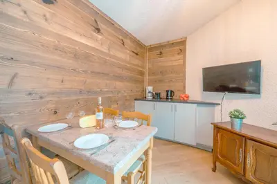 a kitchen with a table with two white plates on it at Chamonix Sud - Bâtiment C 121 - Happy Rentals in Chamonix-Mont-Blanc