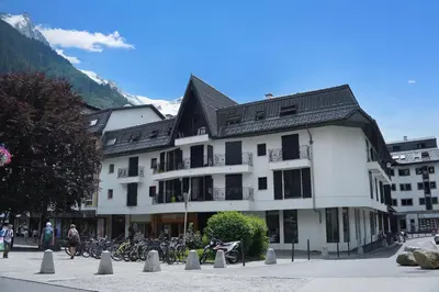 a large white building with bikes parked in the snow at Chamonix Sud - Bâtiment C 121 - Happy Rentals in Chamonix-Mont-Blanc