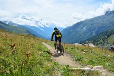 a man walking on a mountain trail with mountains in the background at Chamonix Sud - Bâtiment C 121 - Happy Rentals in Chamonix-Mont-Blanc